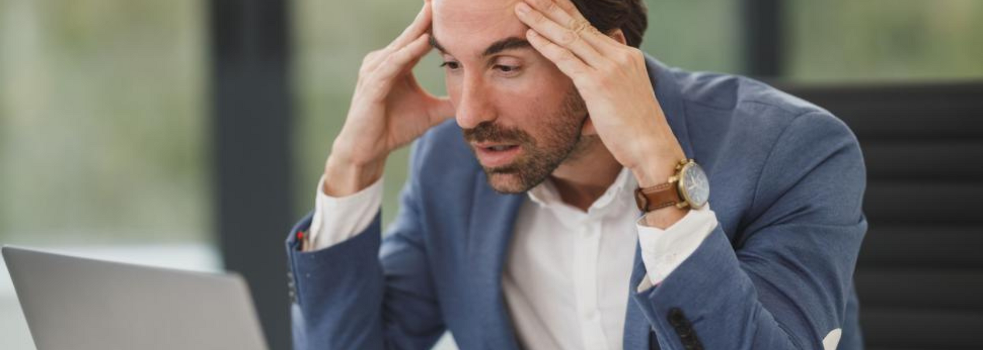 Picture of Man looking stressed at a laptop.