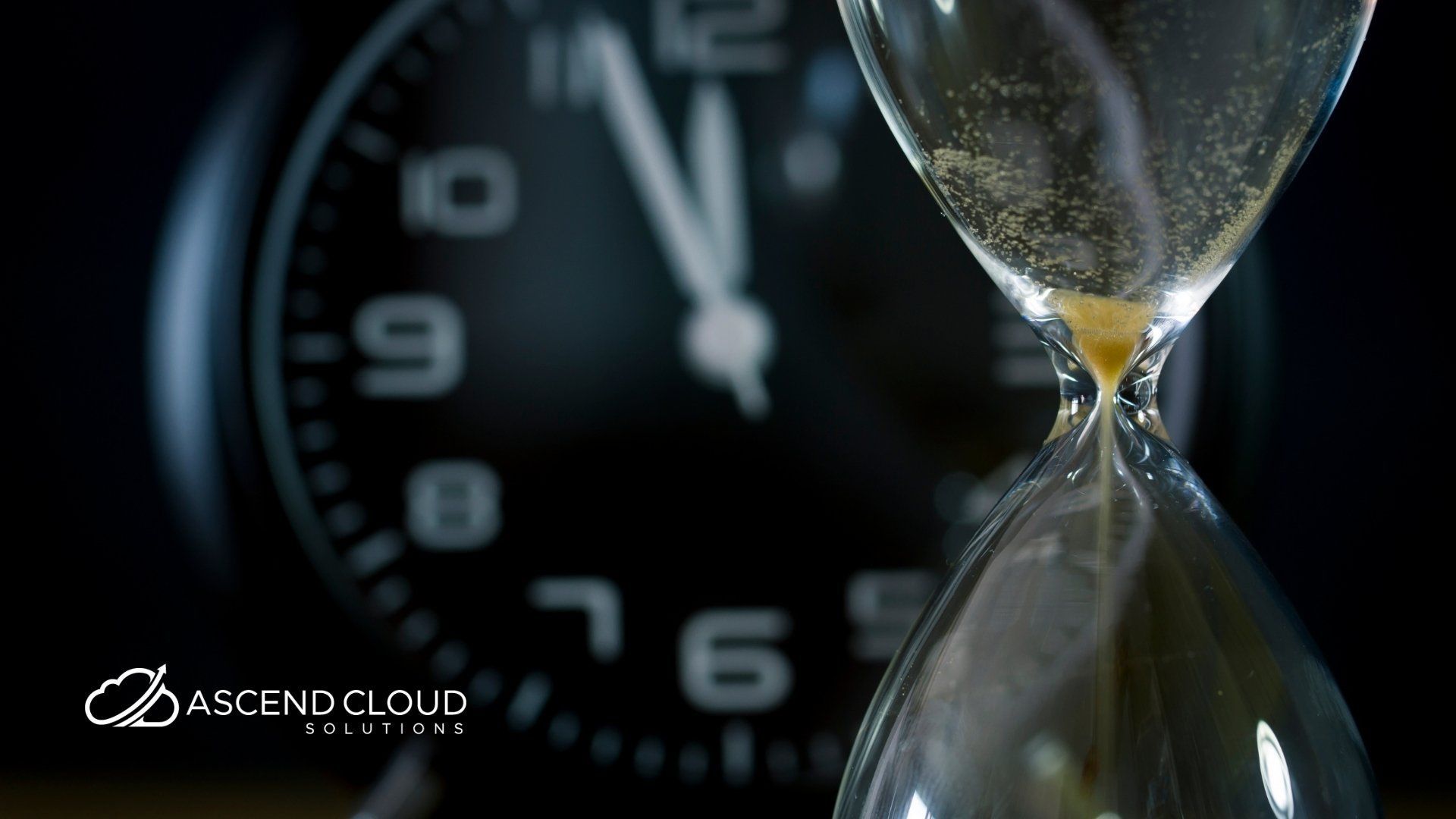 An hourglass is sitting in front of a clock that says ascend cloud