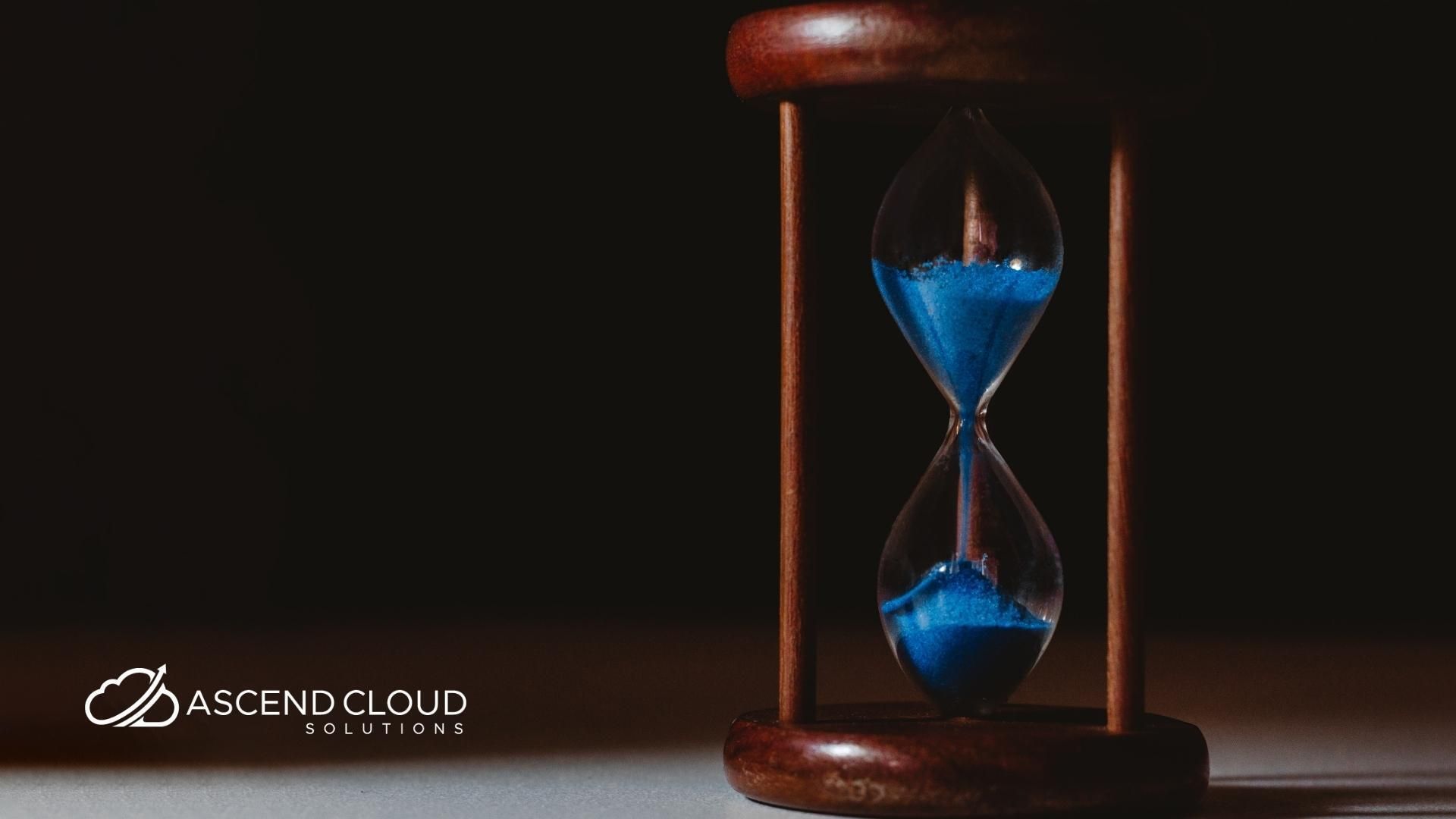 An hourglass with blue sand in it is sitting on a table.