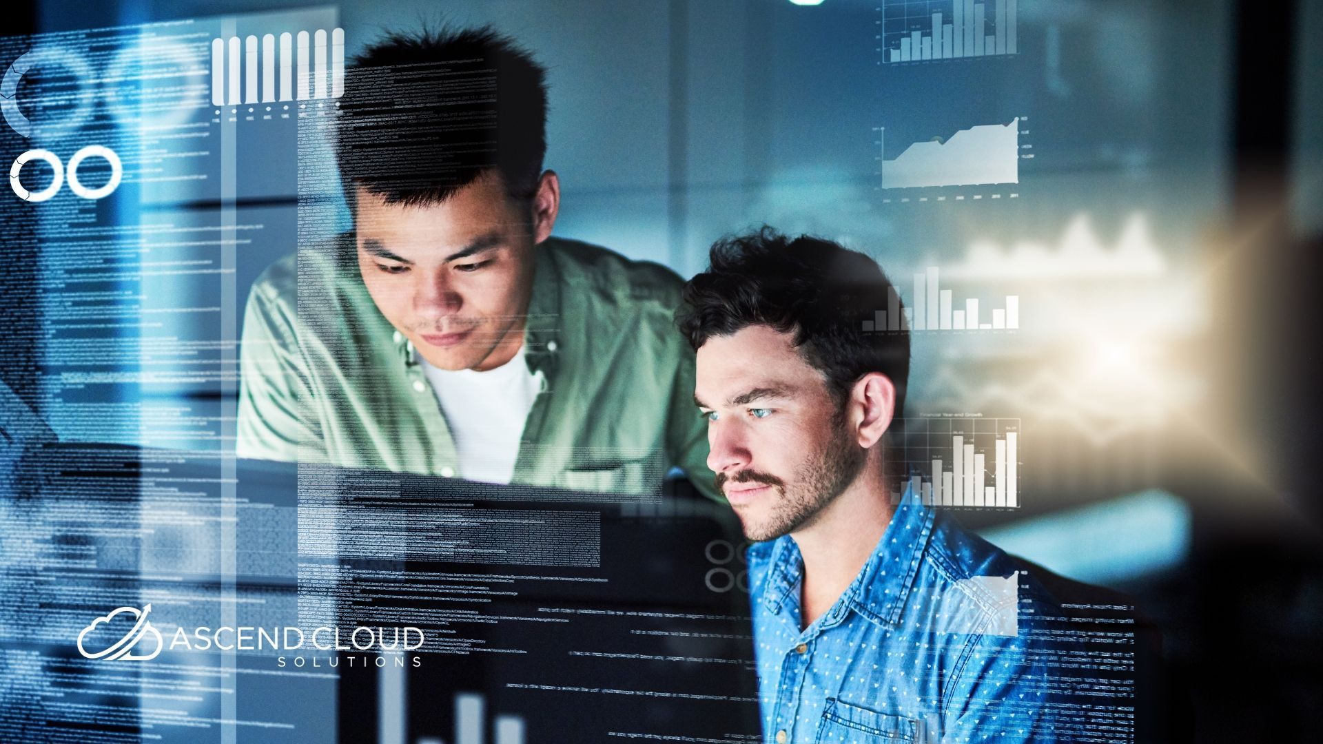 Two men are looking at a computer screen together.