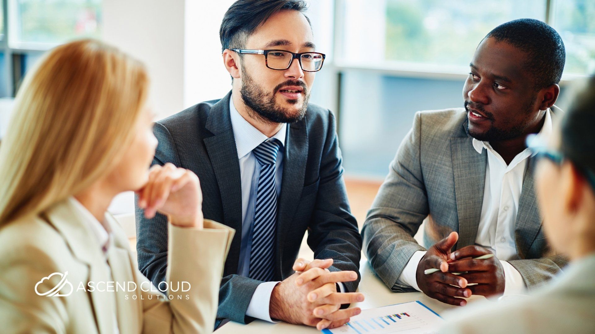 A group of business people are sitting around a table having a meeting.