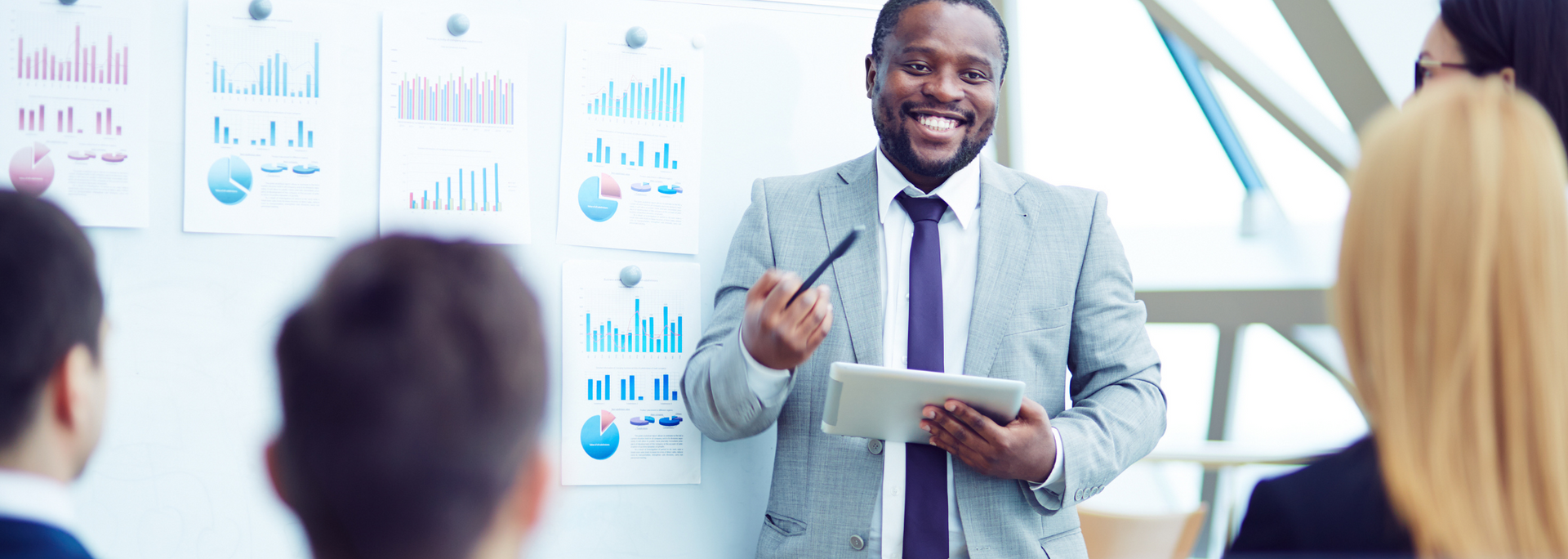 A man in a suit and tie is giving a presentation to a group of people.