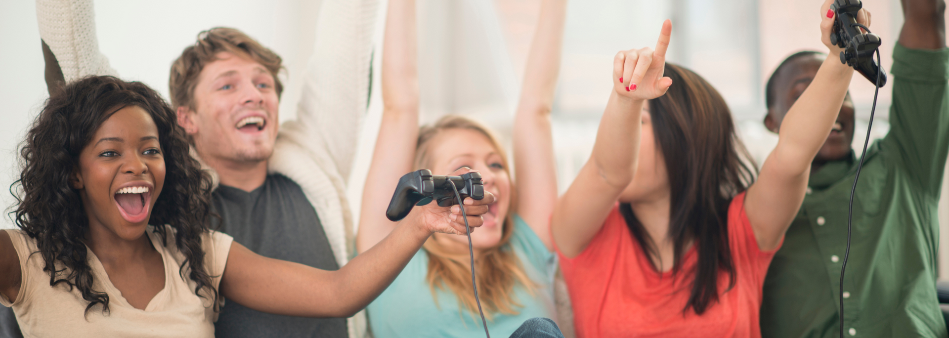 Picture of someone celebrating while holding a game controller.