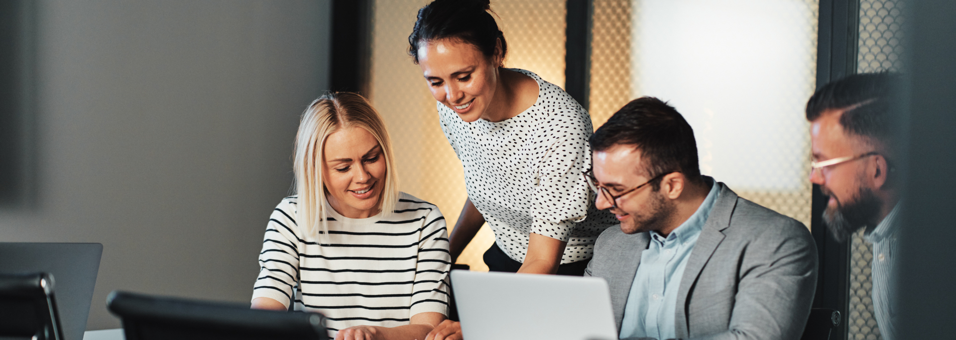 Picture of a number of businesspeople talking over a laptop.