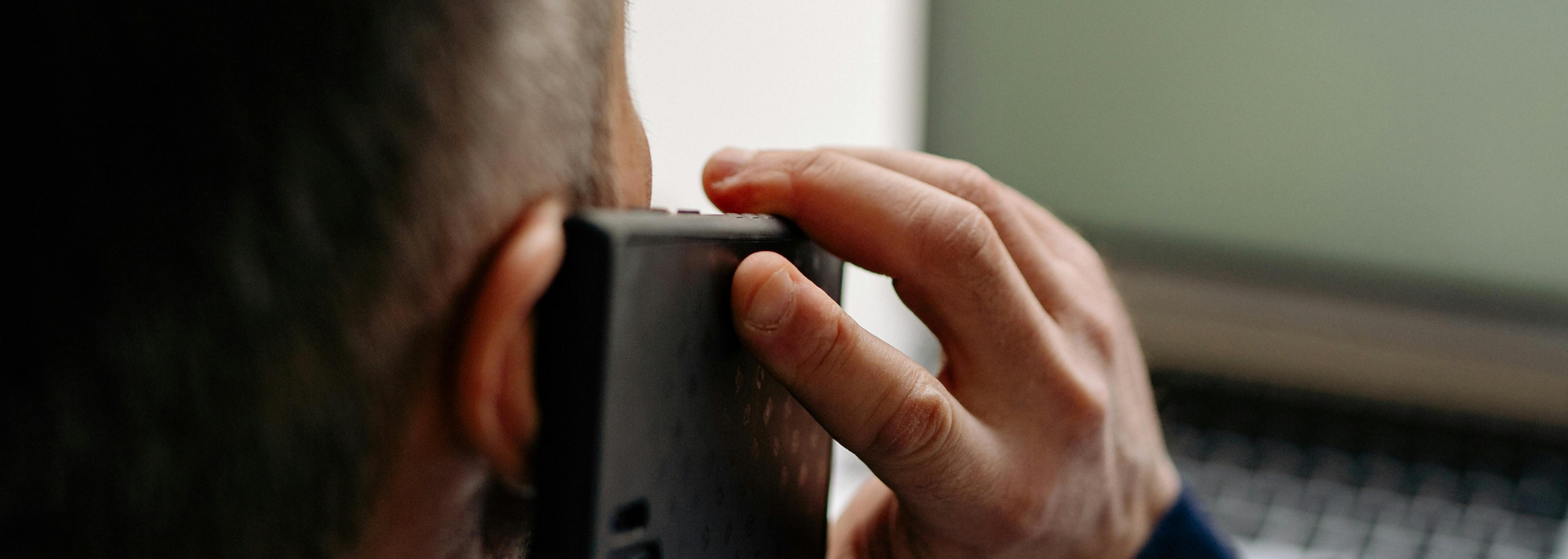 Picture of a person at a desk on a phone call.