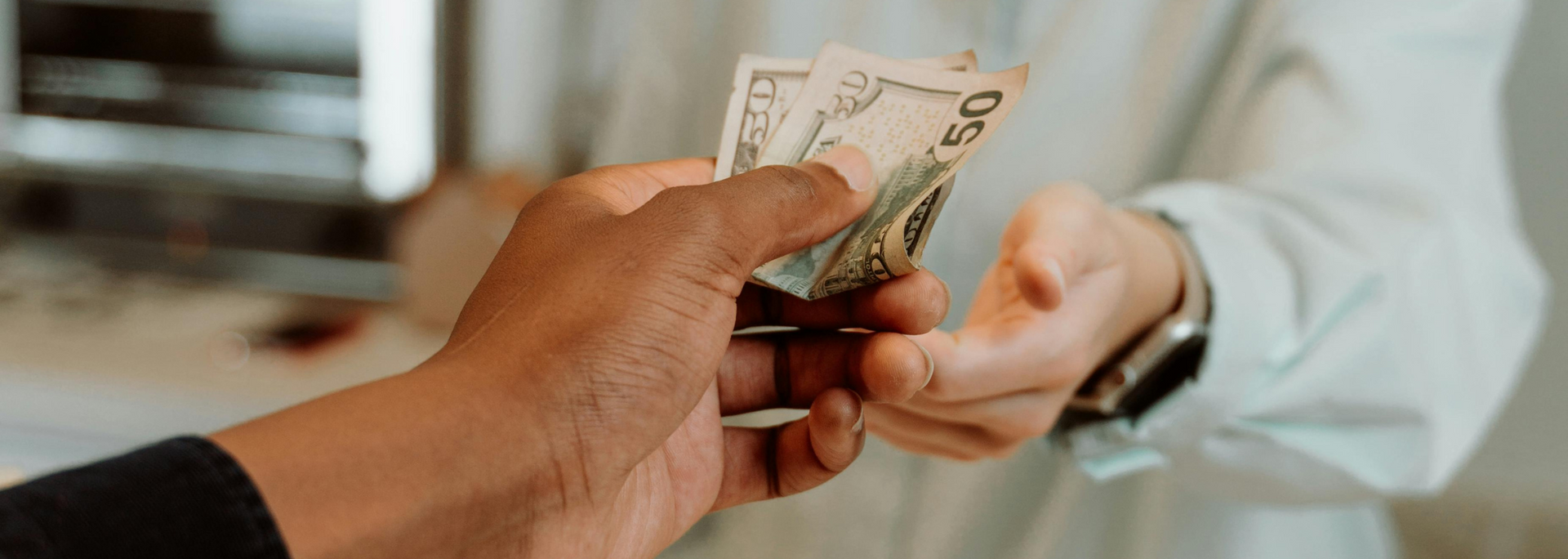 Picture of someone handing over money in a shop.