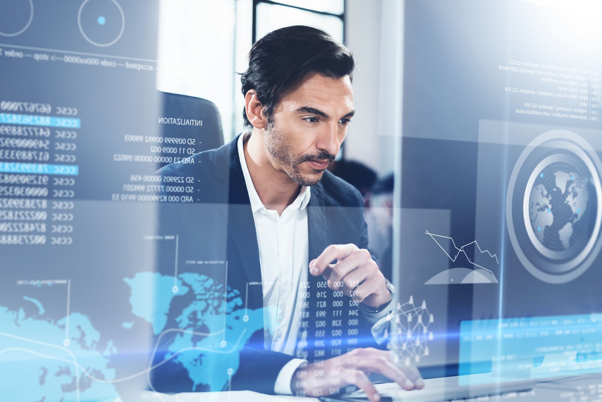 A man in a suit is sitting in front of a computer.