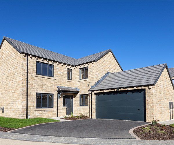 tan brick home with dark teal garage door