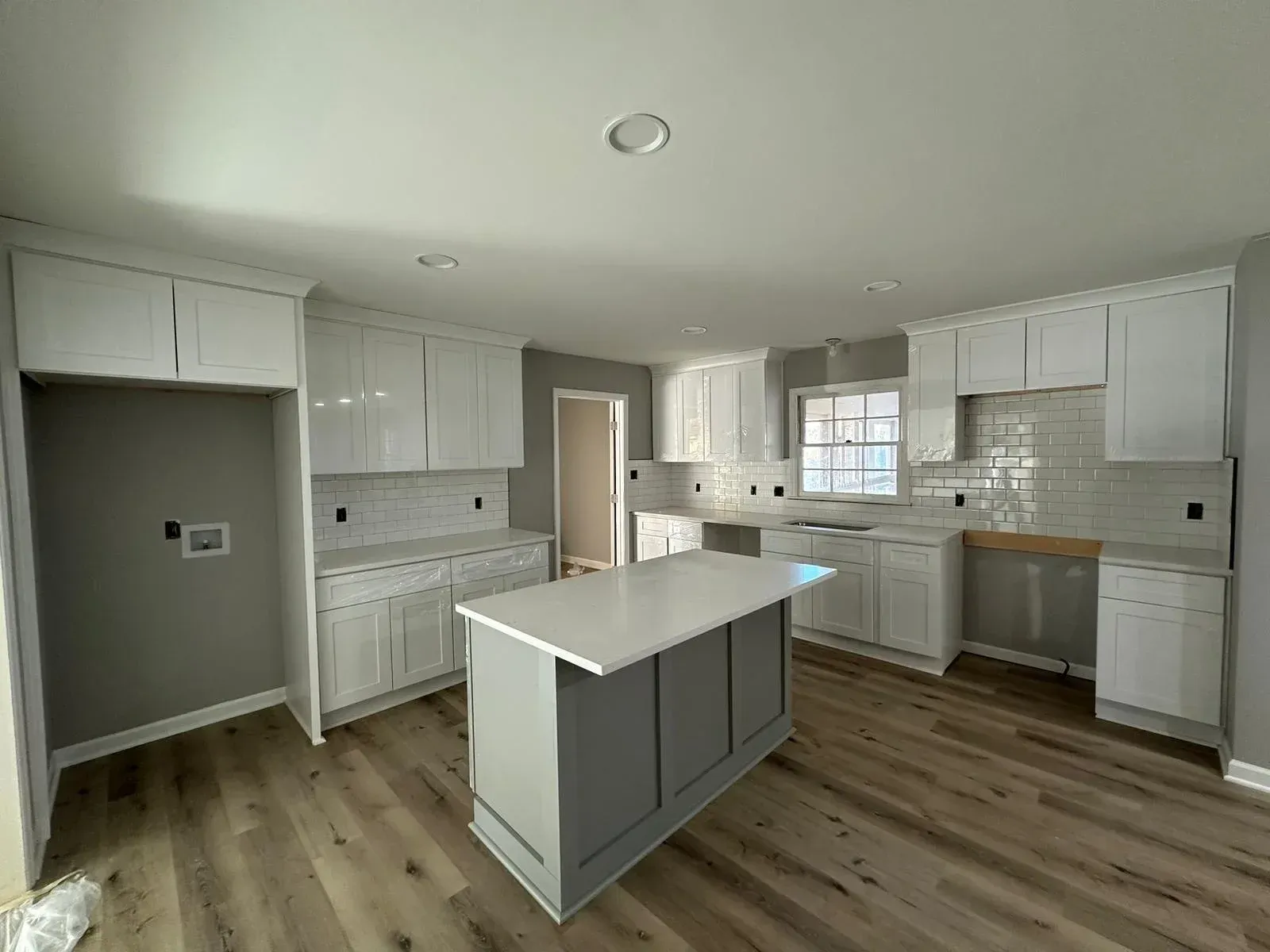 A kitchen with white cabinets and a large island in the middle.