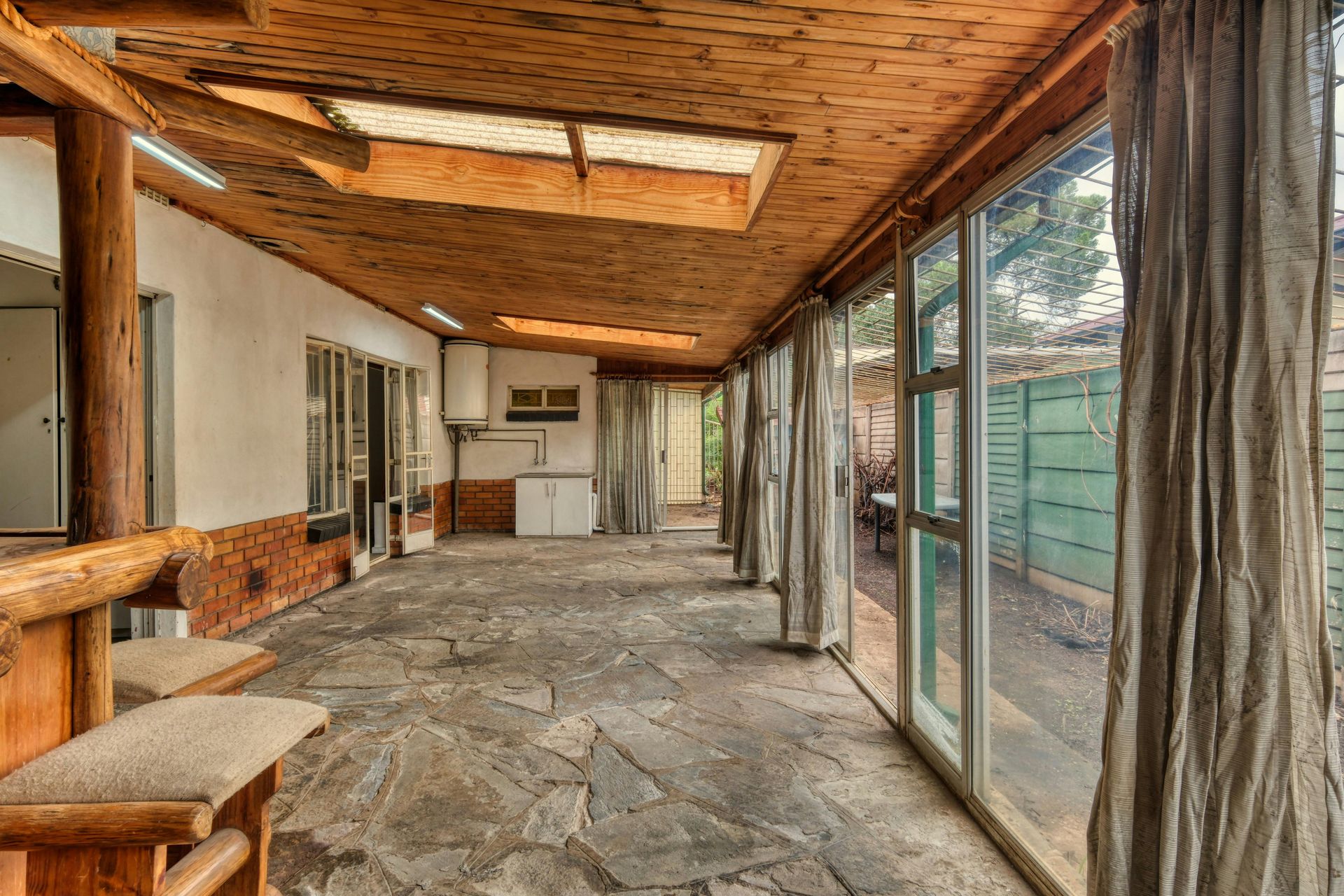 A large room with a lot of windows and a wooden ceiling.