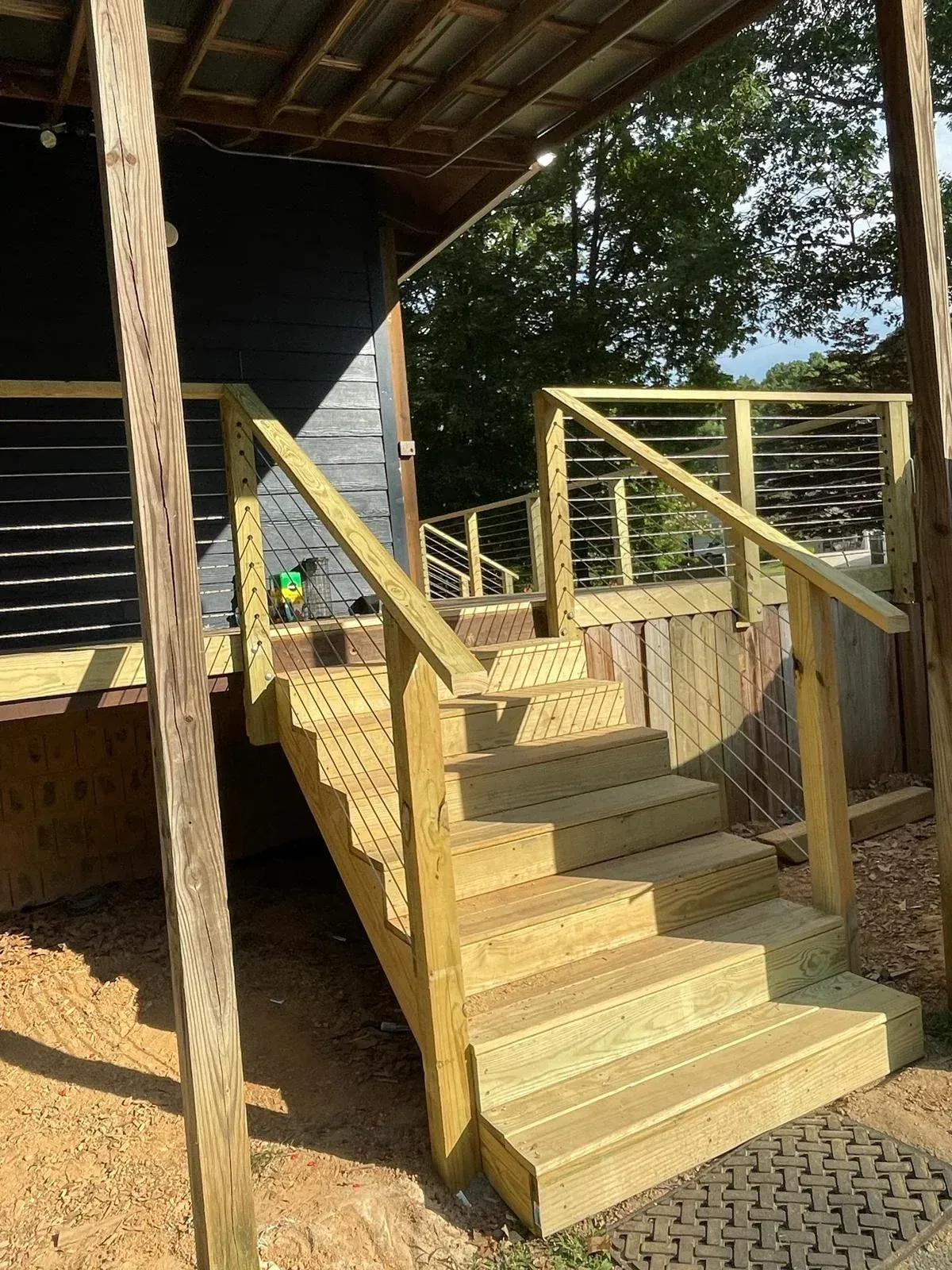 A wooden deck with stairs and a metal railing.
