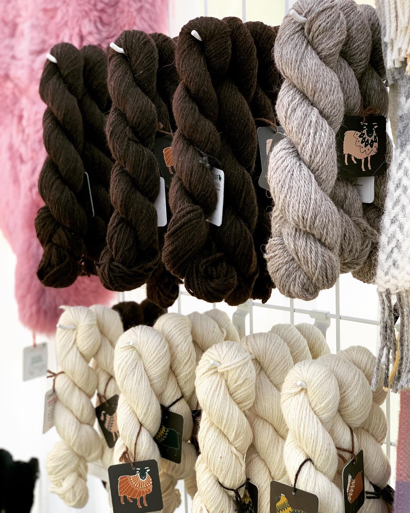 Skeins of brown, gray, and off-white yarn displayed on a grid.