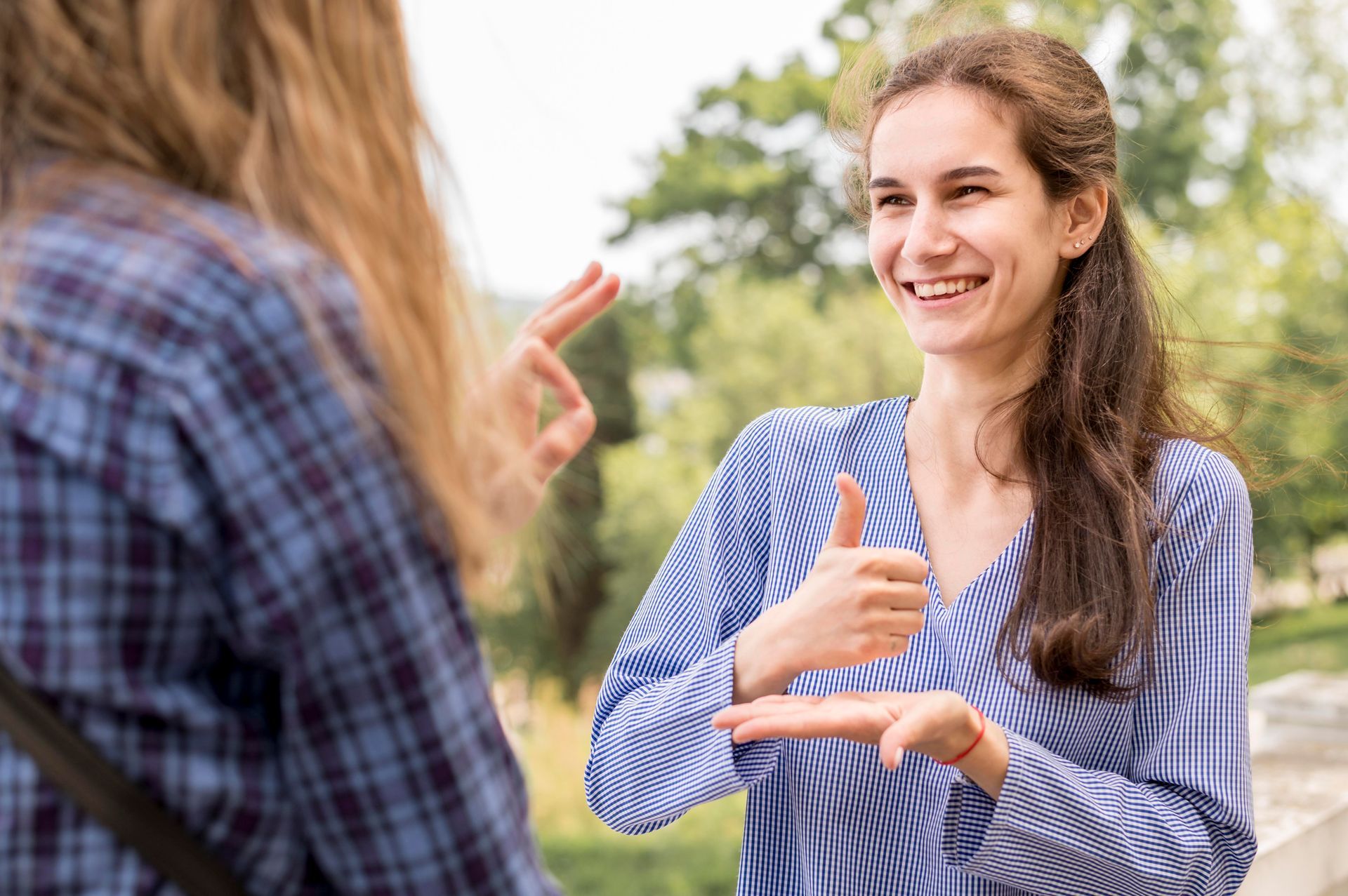 A woman is using sign language to communicate with another woman.