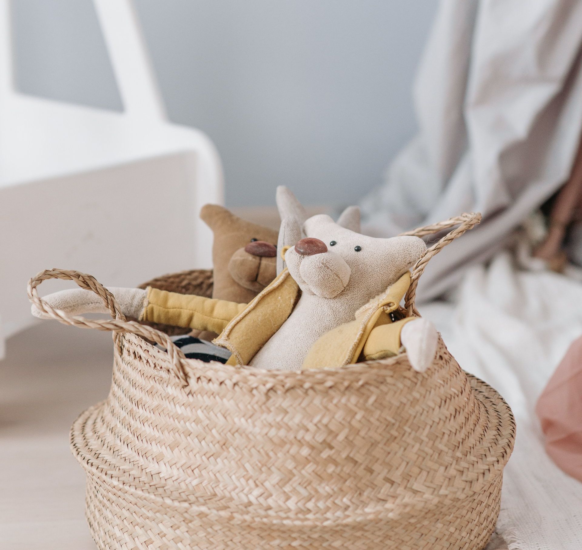 A person is holding a basket filled with stuffed animals.