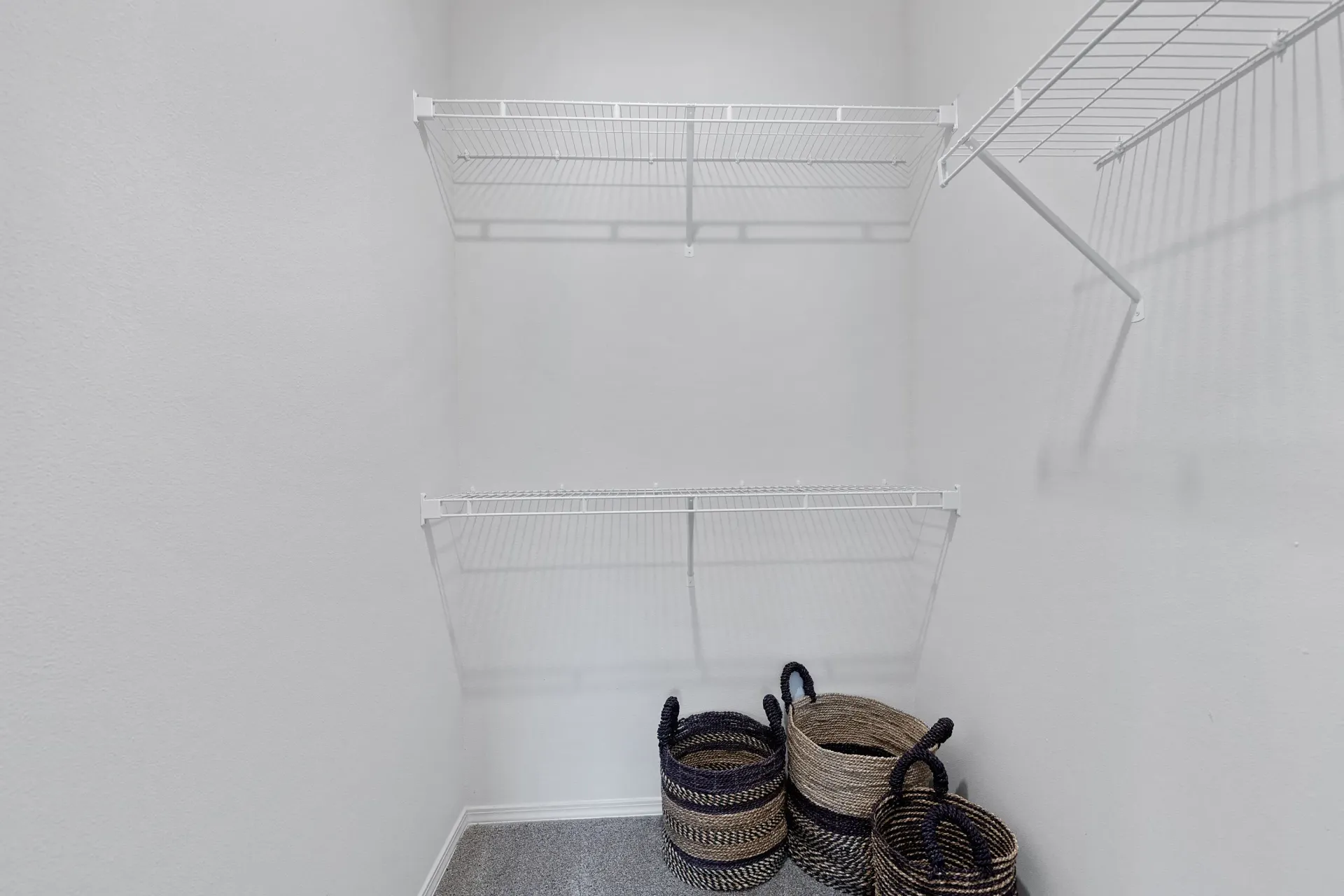 Empty closet with wire shelving and decorative baskets