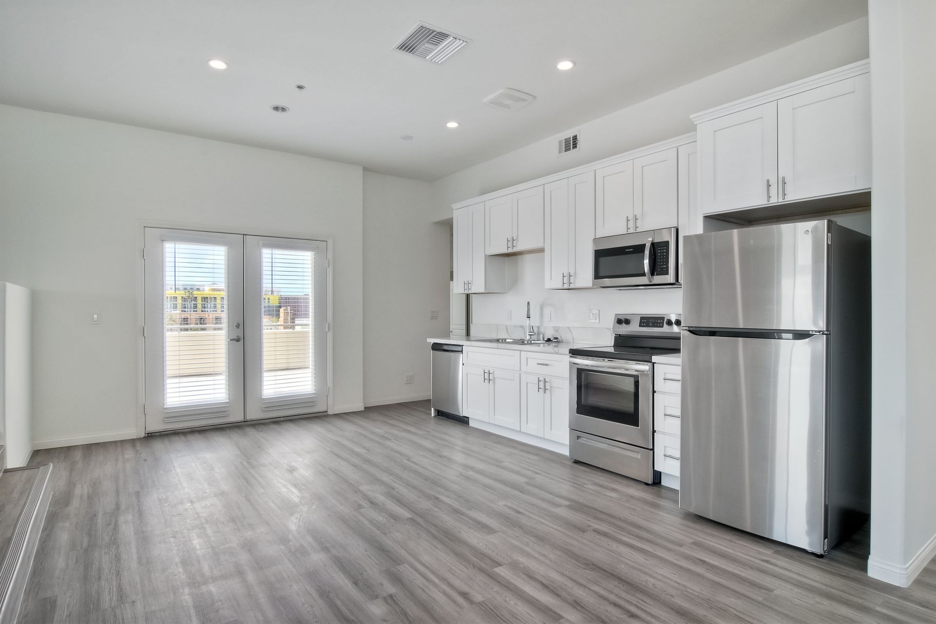 Photo of the kitchen, with dual doors to go out onto the balcony