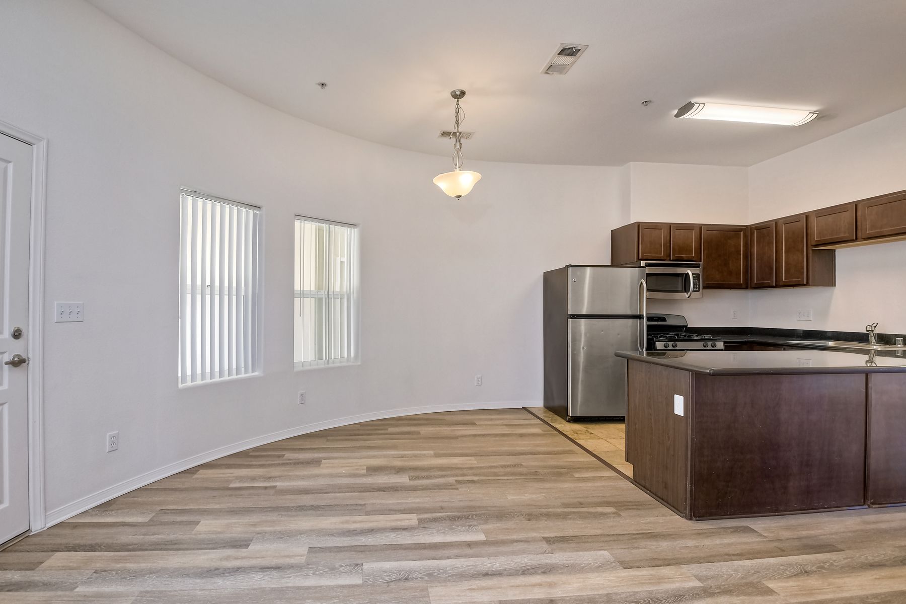 Photo of a room with a very rounded wall, and the kitchen nearby