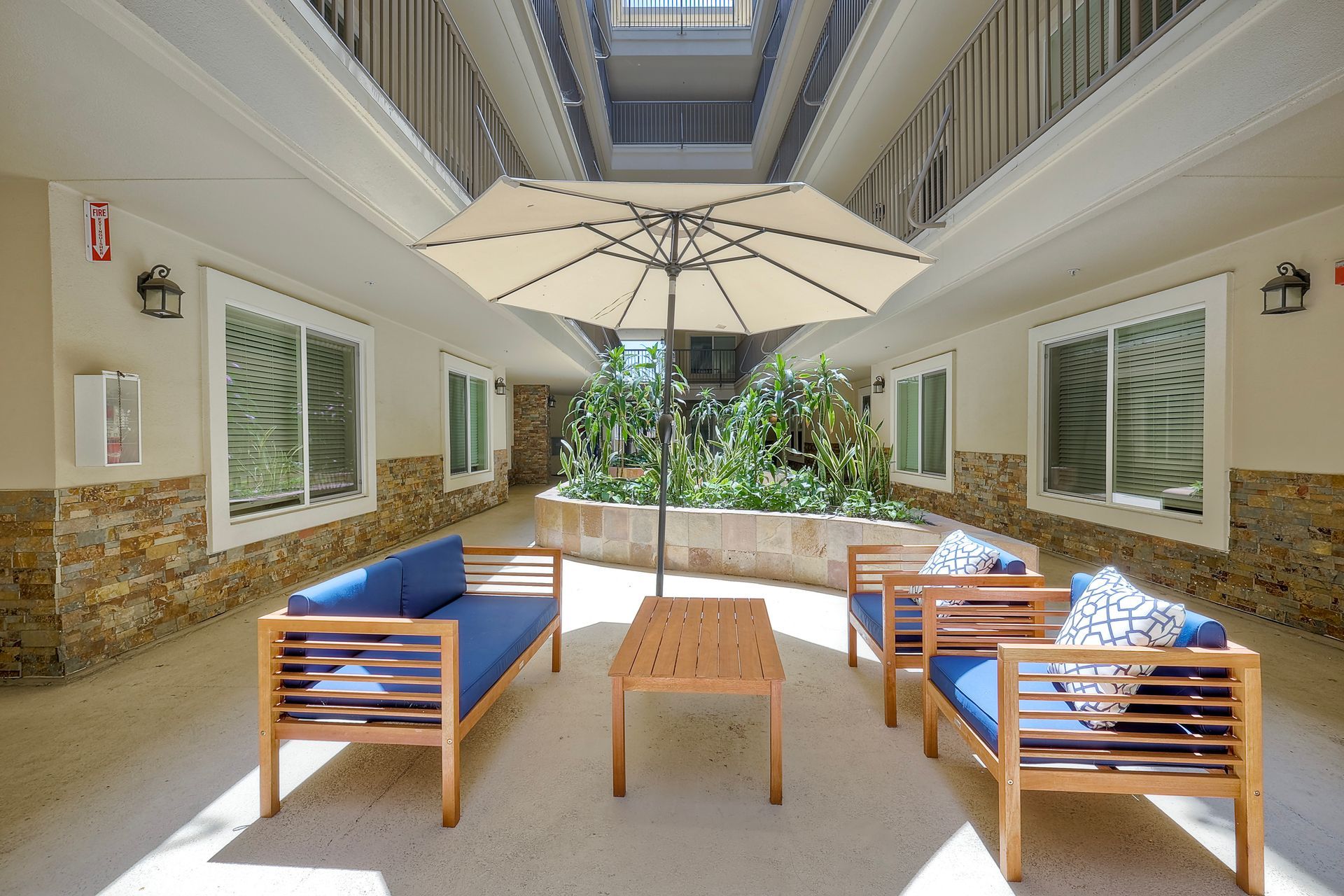 Photo of an interior courtyard with seating protected by an umbrella