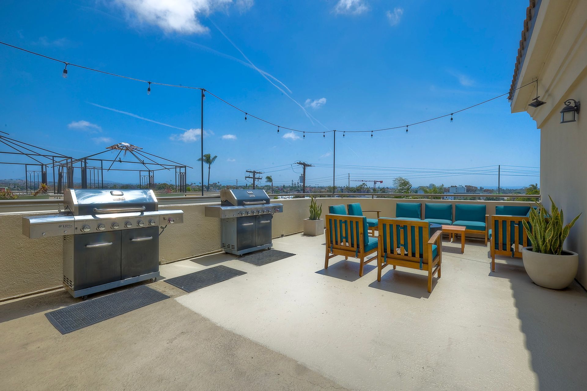 Photo of a rooftop space showing seating and barbecue grills
