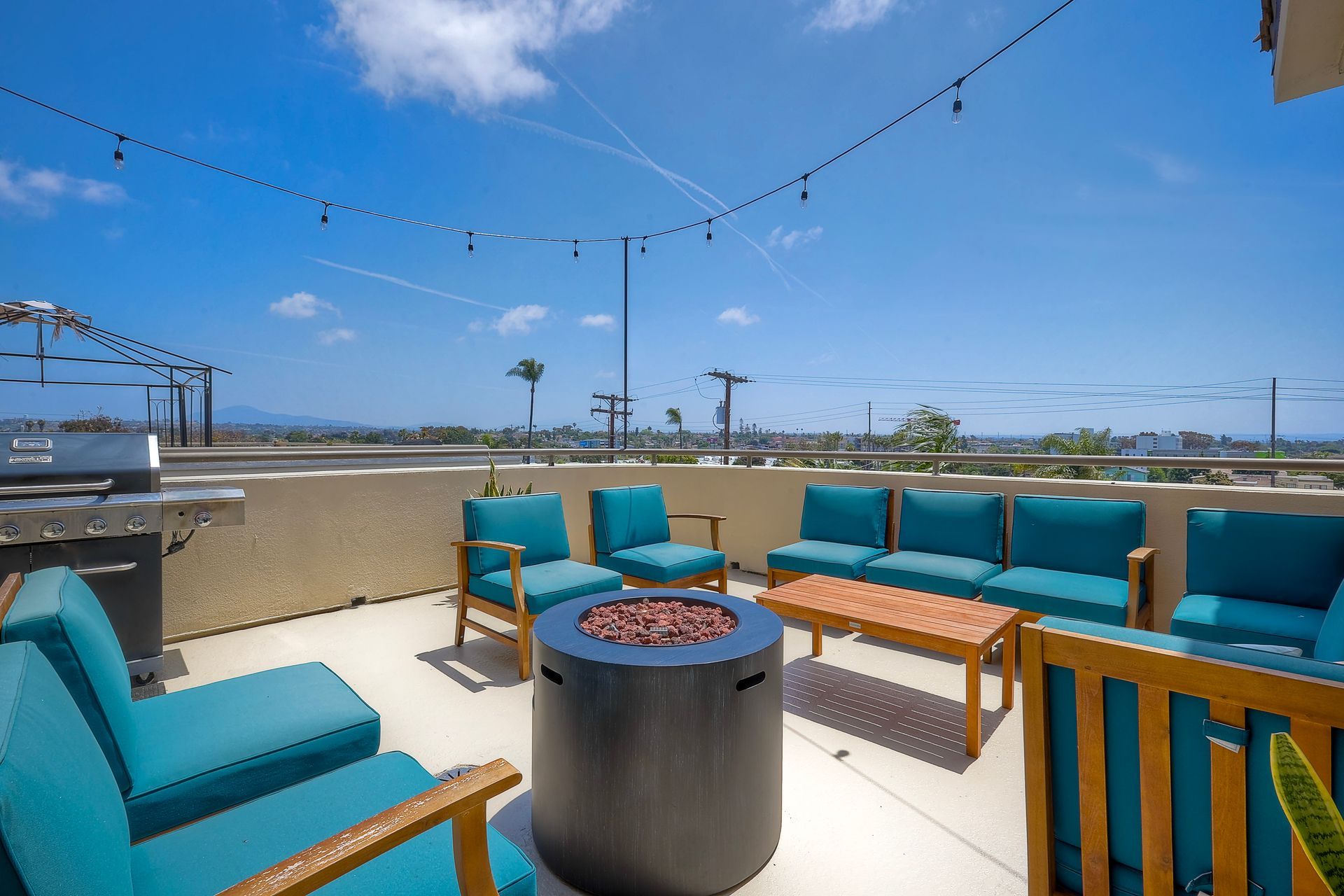 Photo of a rooftop seating area with a firepit in the middle