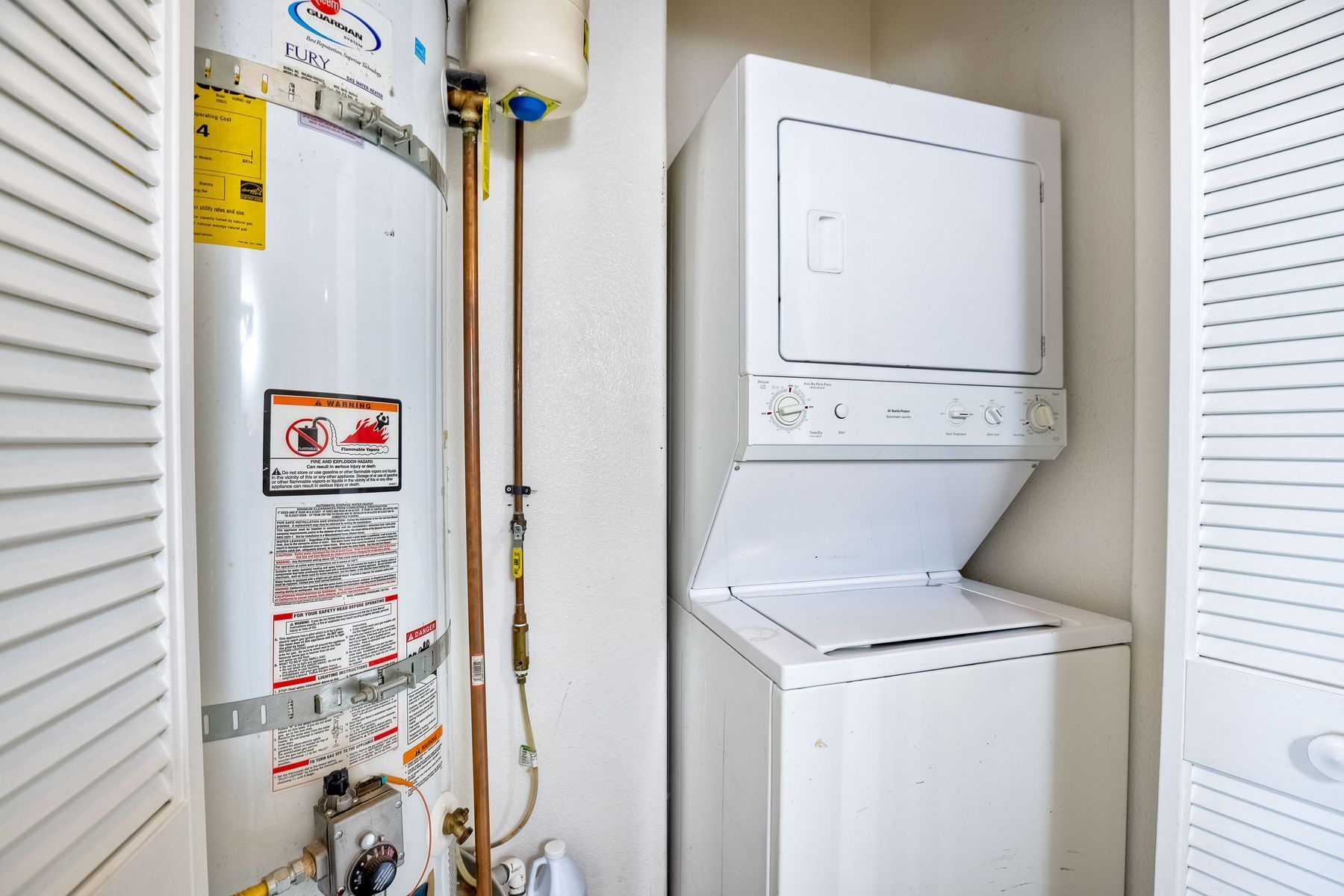 Photo of a space showing a water heater and a washer/dryer combo