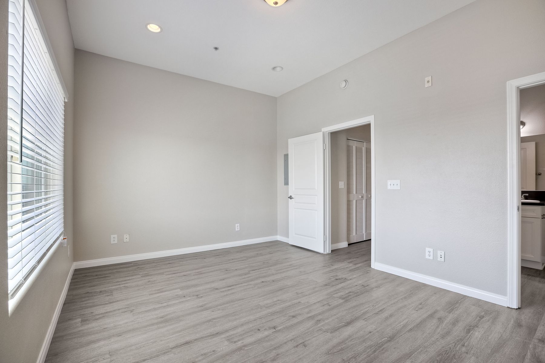 Photo of a large bedroom with plenty of natural light and a high ceiling