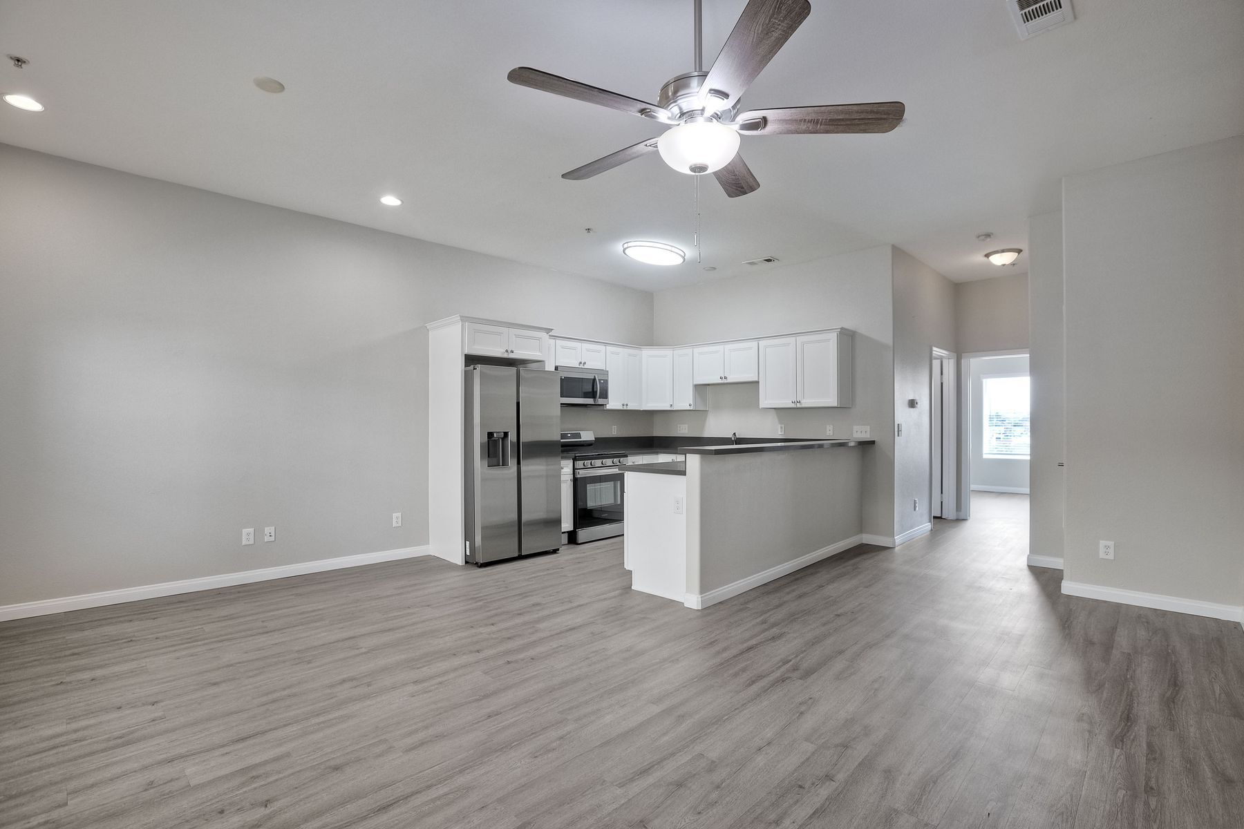 Photo of a dining area space, with the kitchen in the middleground