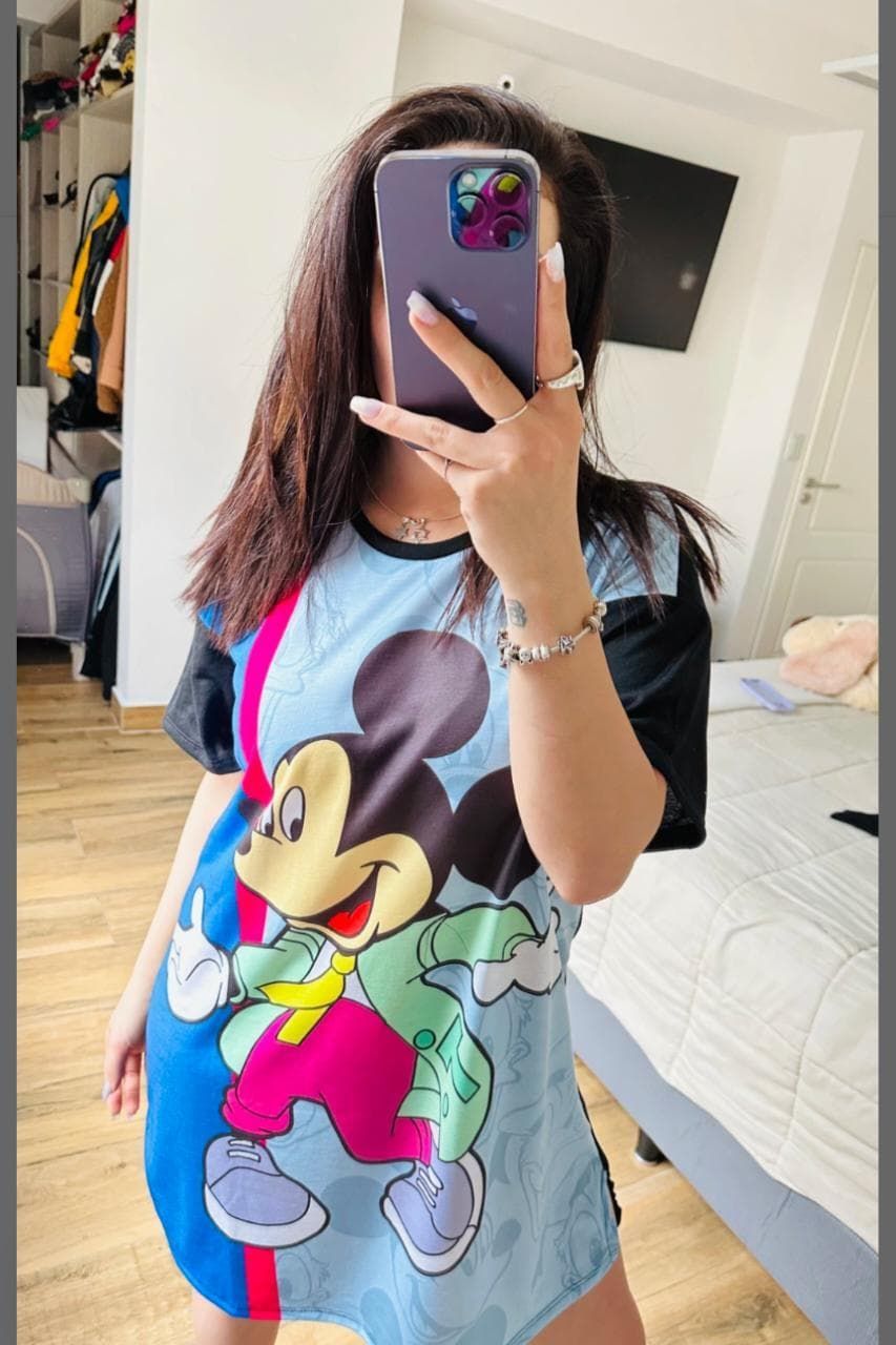 Persona sosteniendo un teléfono, vistiendo una camiseta azul de Mickey Mouse.