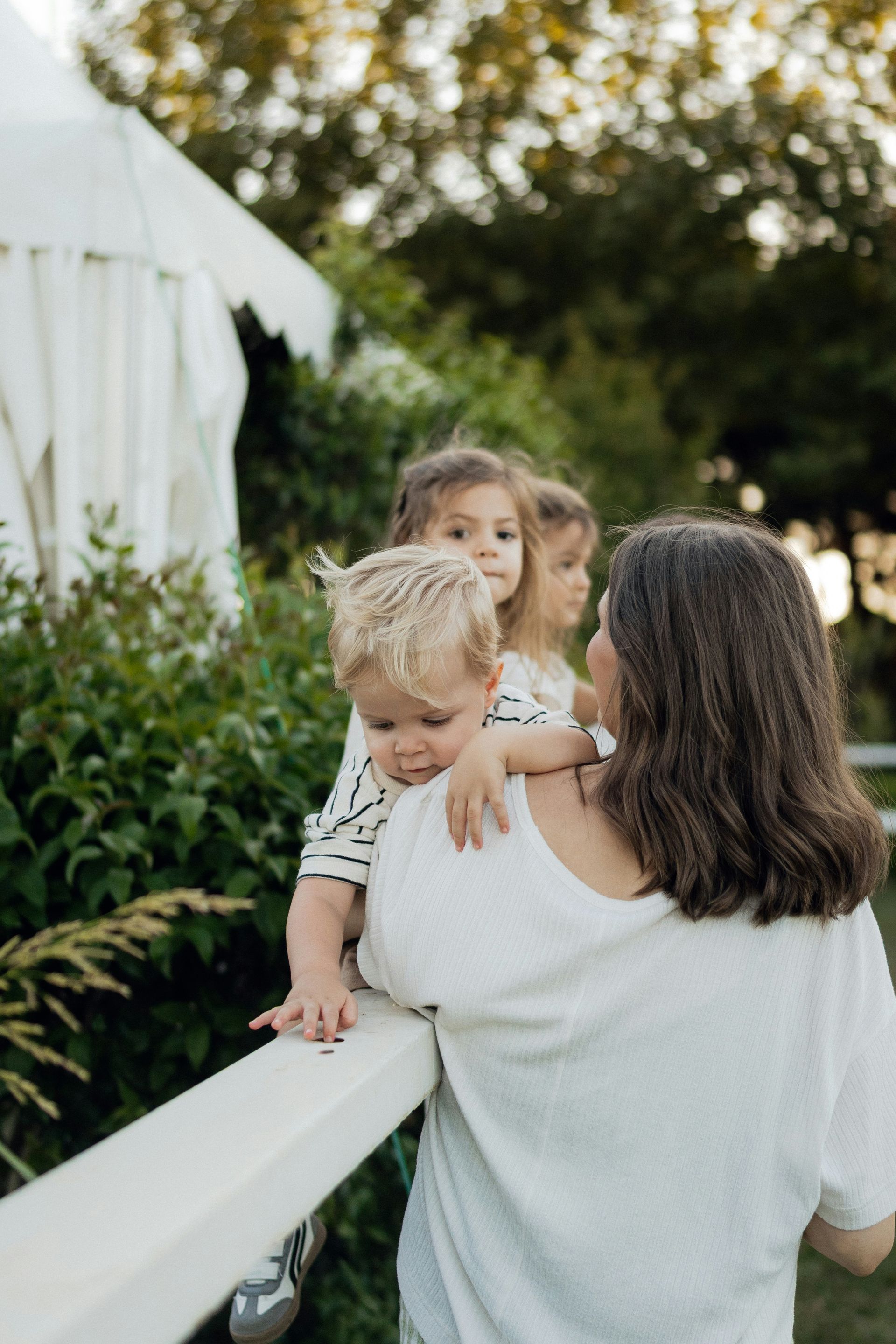 Family loading luggage into a car trunk; smiling people gather outdoors. 
