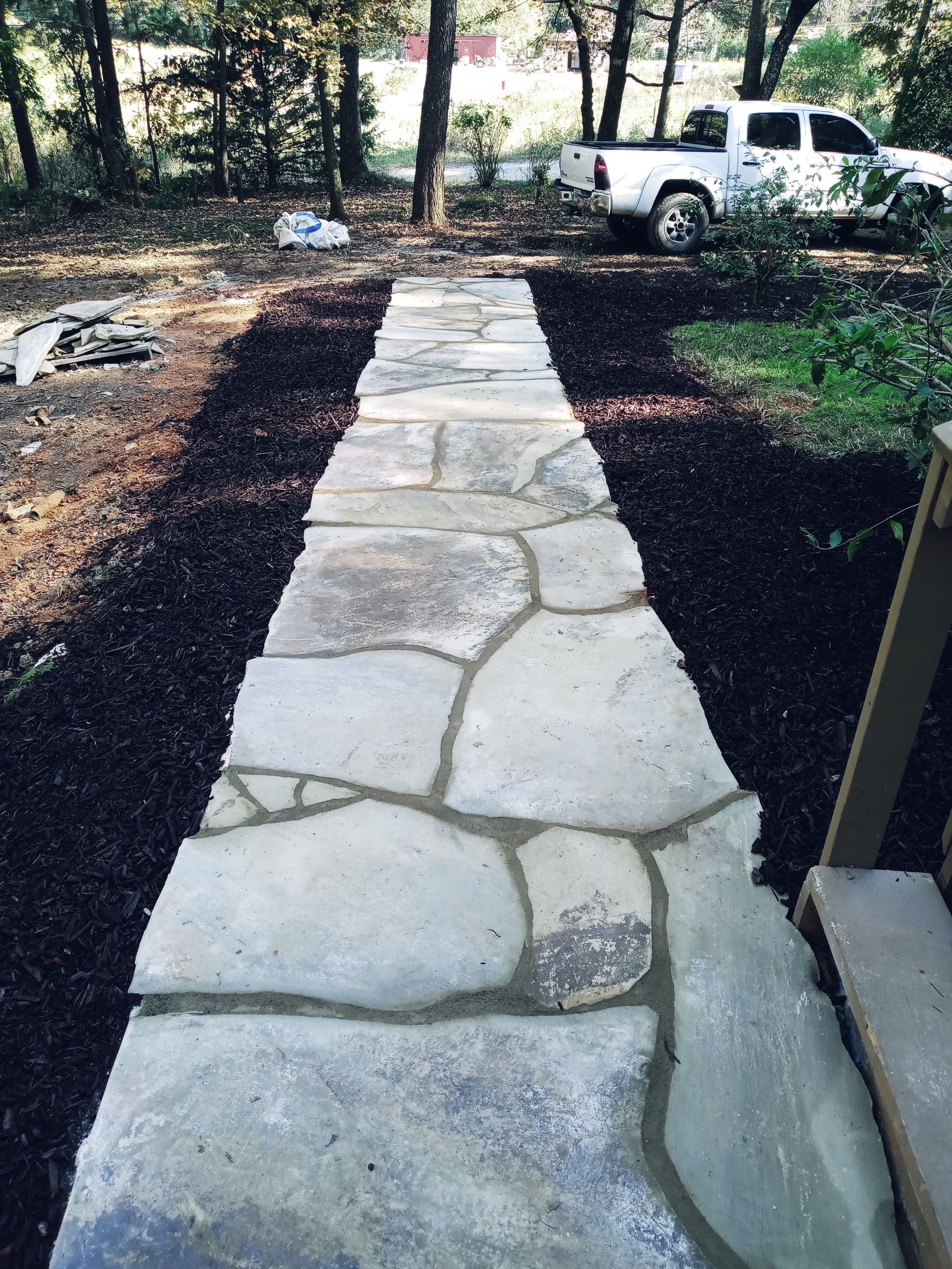 A white truck is parked on the side of a stone walkway