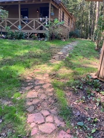 A stone path leading to a cabin in the woods.