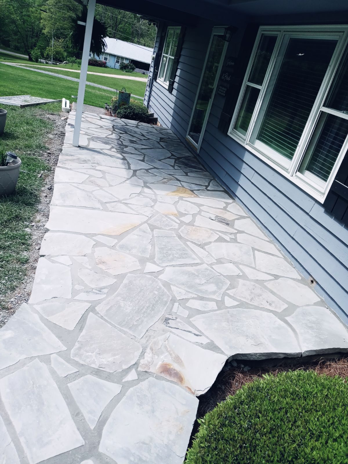 A stone walkway leading to the front of a house.