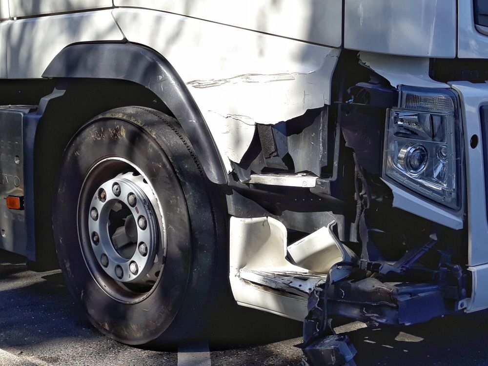 A White Truck With a Damaged Side is Parked on the Side of the Road — ACT Law Associates In Tuggeranong, ACT