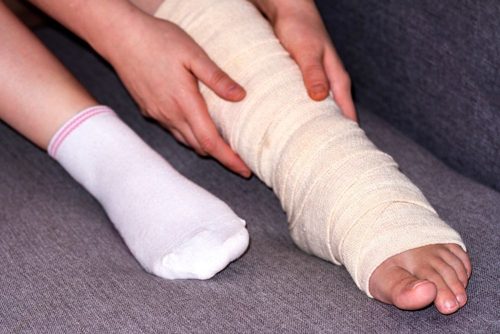 A Person With a Bandaged Leg is Sitting on a Couch — ACT Law Associates In Canberra, ACT