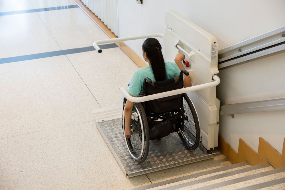 A Woman in a Wheelchair is Using a Lift to Get Up the Stairs — ACT Law Associates In Fyshwick, ACT
