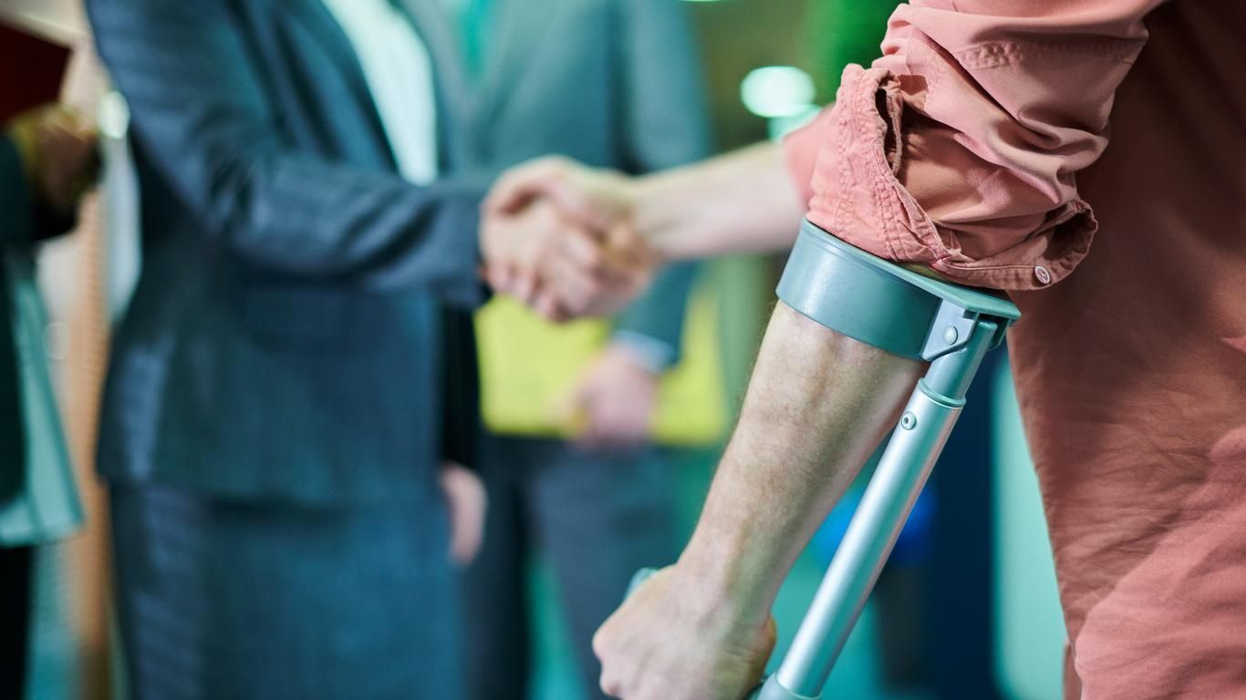 A Man With Crutches is Shaking Hands With a Woman — ACT Law Associates In Gungahlin, ACT