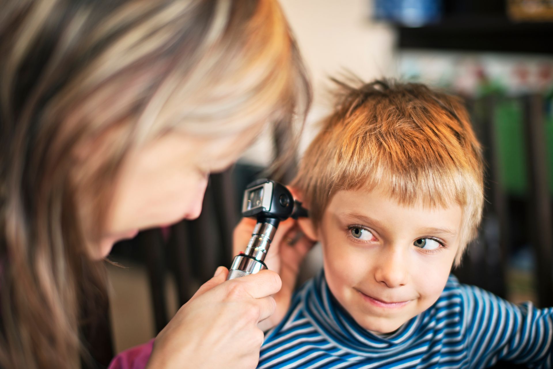 Boy having his ears checked by a pediatrician