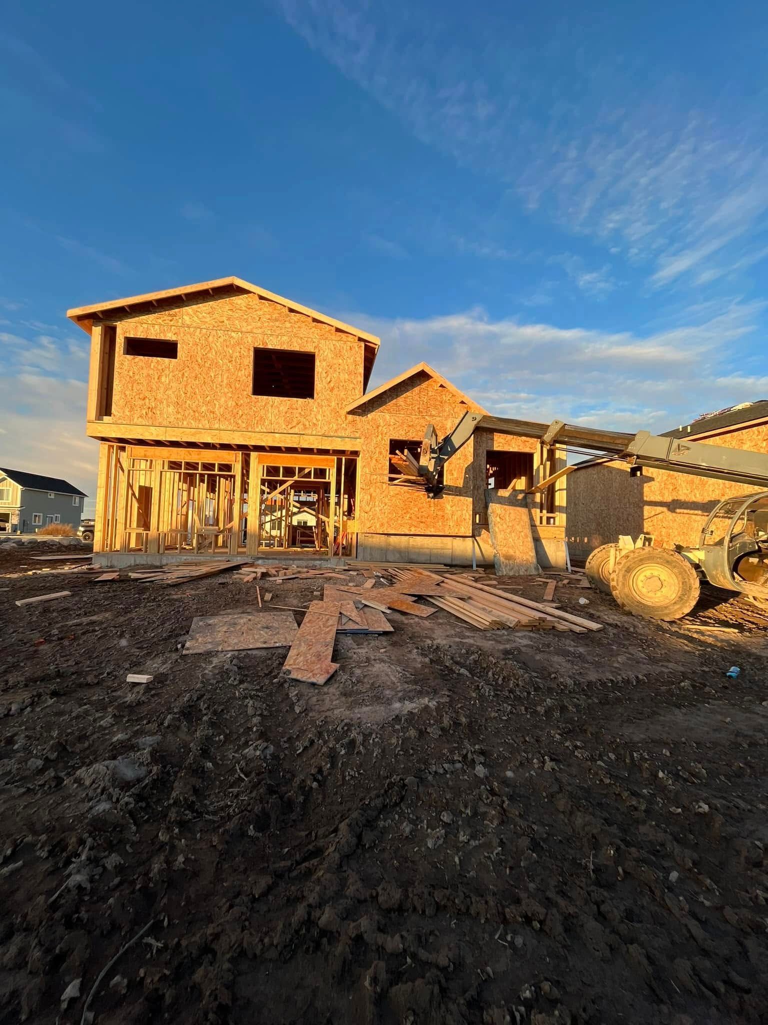 A house is being built in the middle of a dirt field.