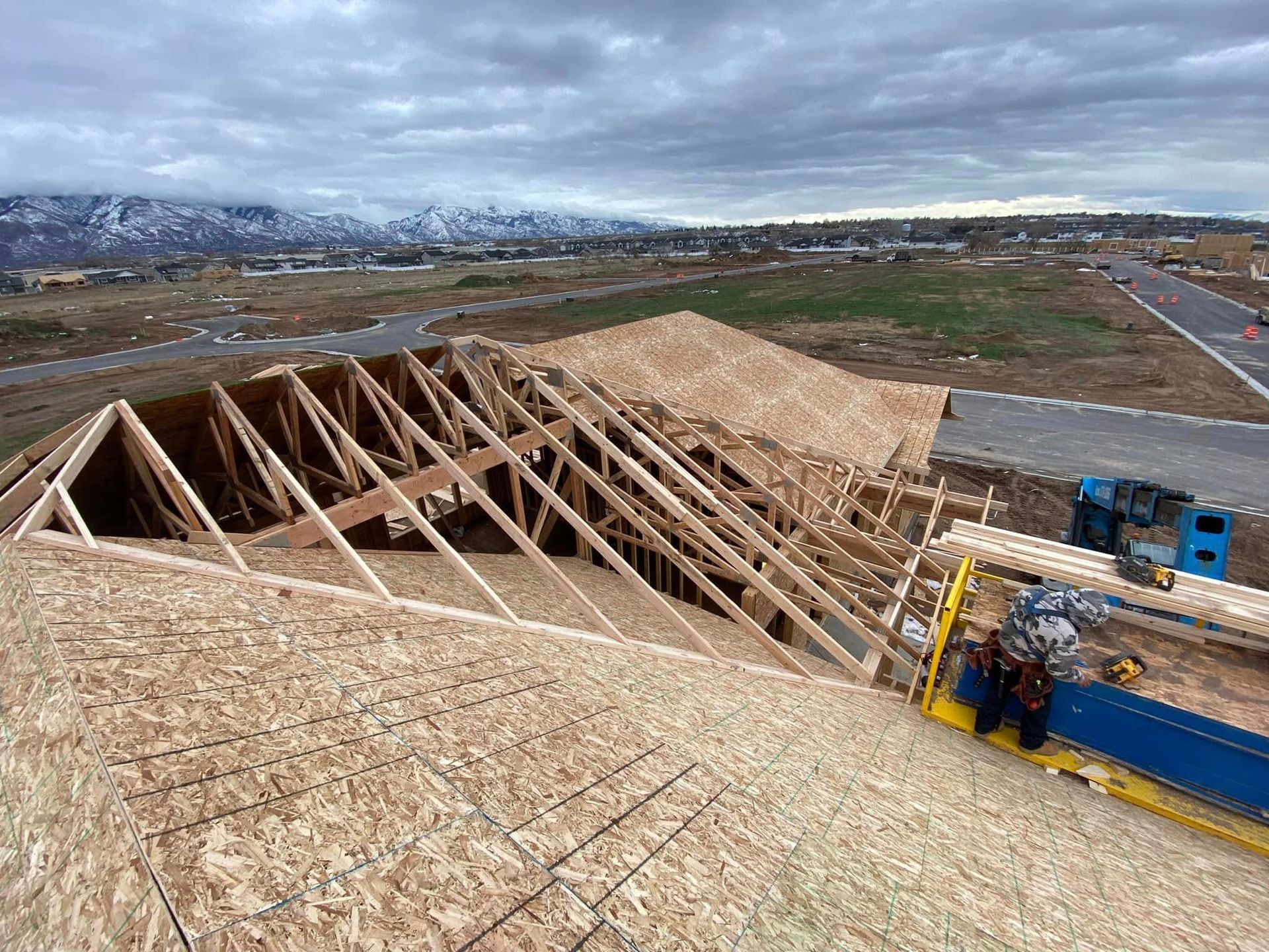 A large wooden structure is being built on top of a hill.