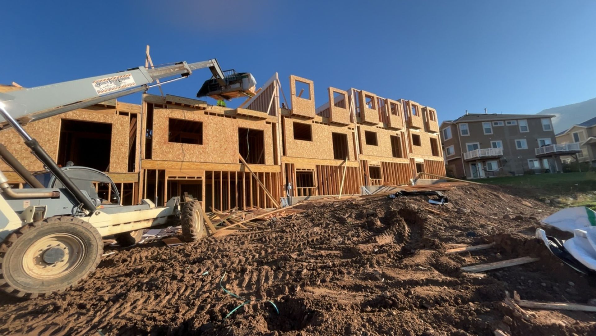 A construction site with a building under construction and a bulldozer in the foreground.