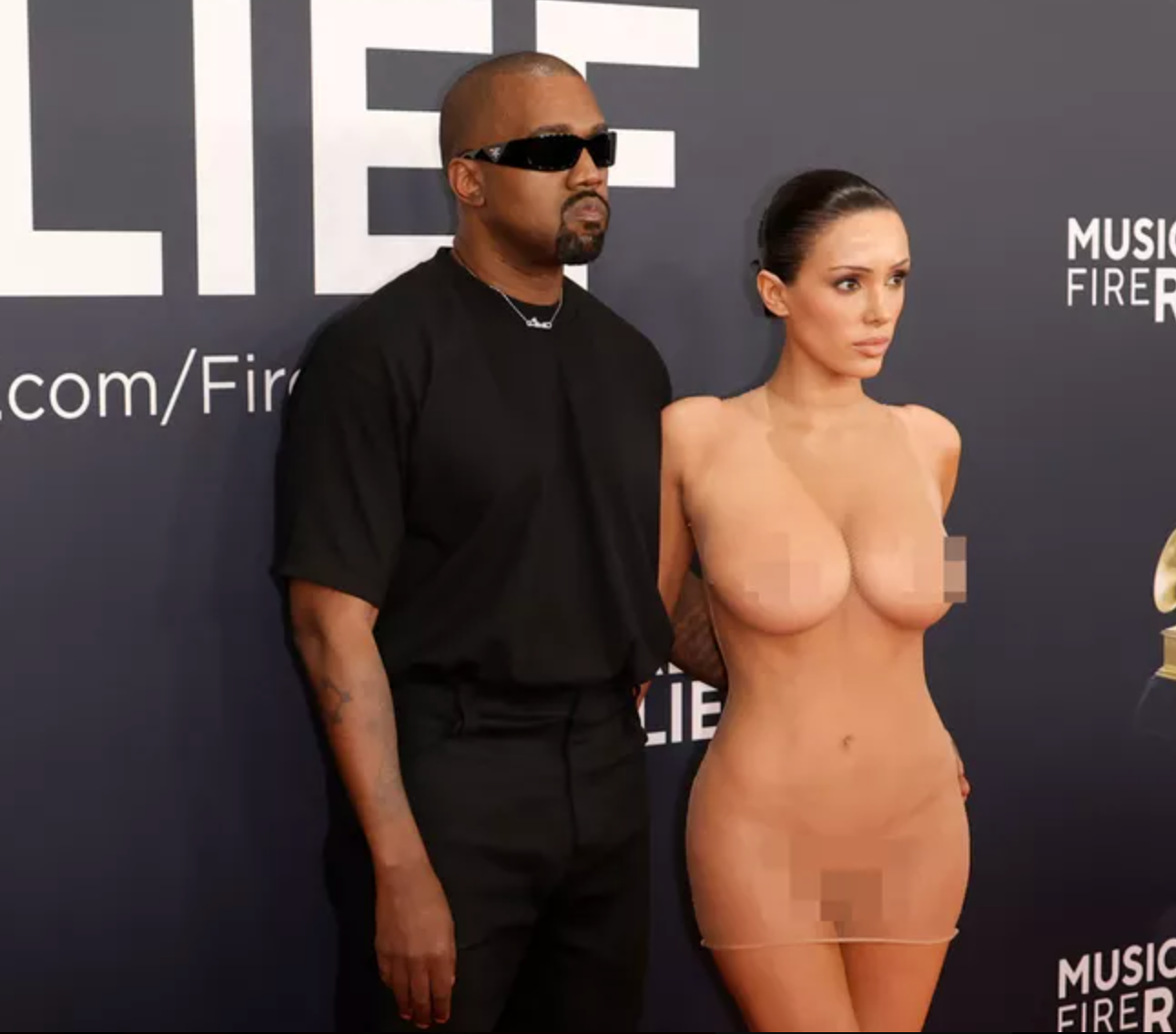 Kanye West, wearing clothing, next to his wife Bianca Censori, wearing a completely transparent dress without underwear, at the 2025 Grammys.