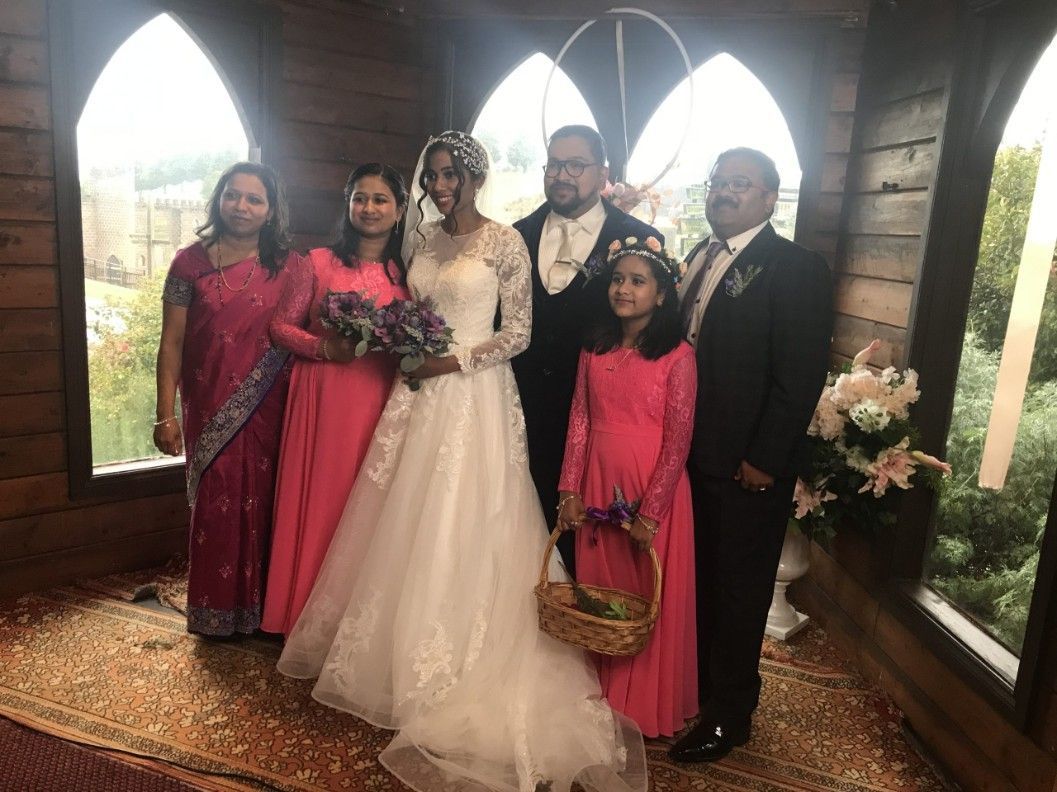 A Bride and Groom Are Posing for A Picture with Their Wedding Party