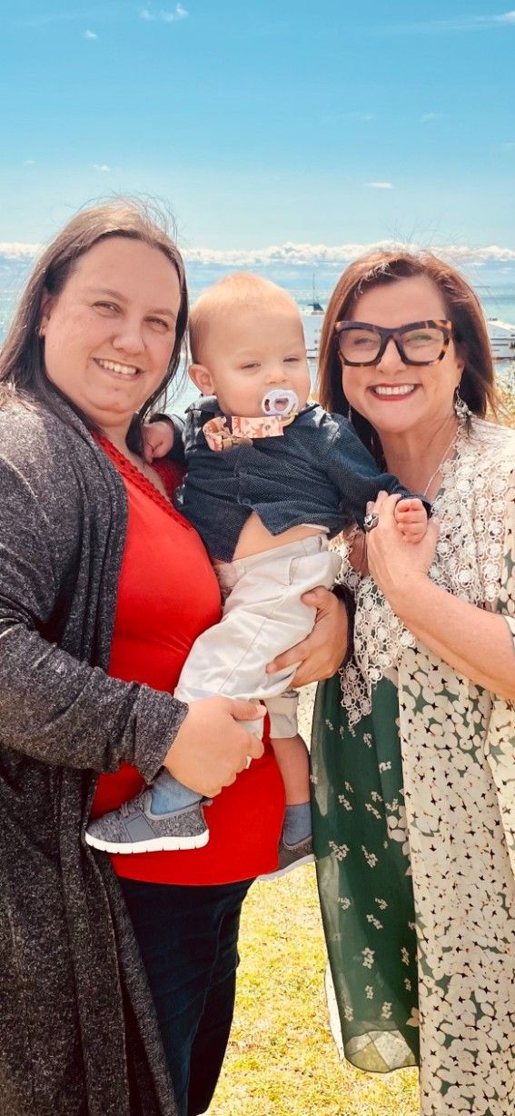 Two Women Are Standing Next to Each Other Holding a Bab