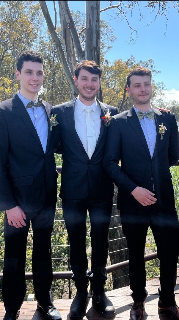 Three Men in Suits and Bow Ties Are Posing for A Picture