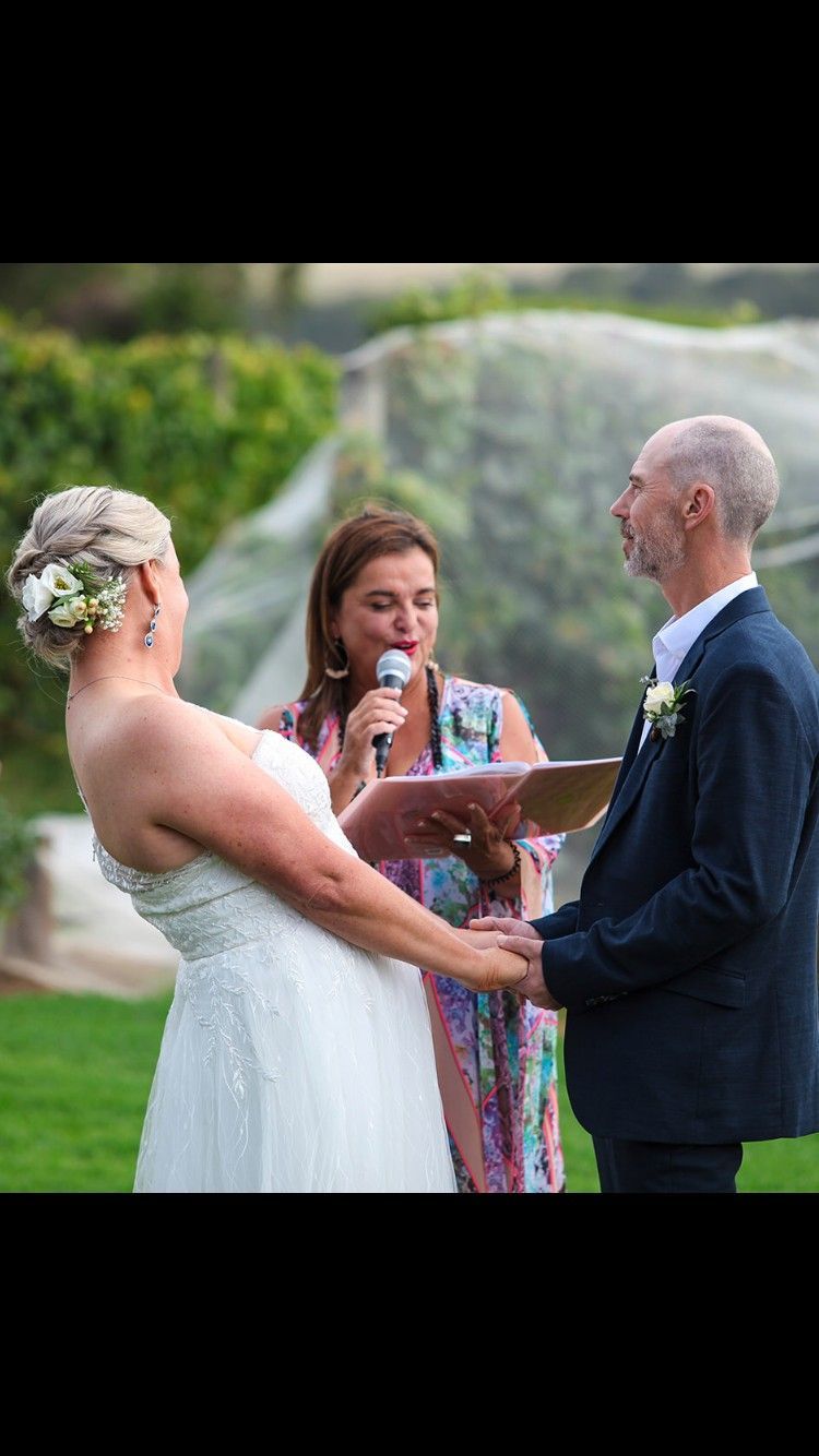 A Bride and Groom Are Holding Hands During Their Wedding Ceremony