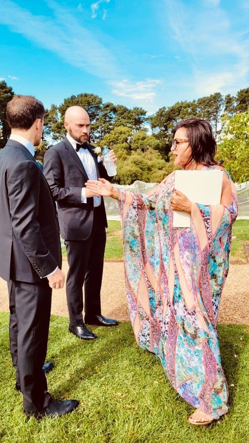 A Woman in A Long Dress Is With Two Men in Suits