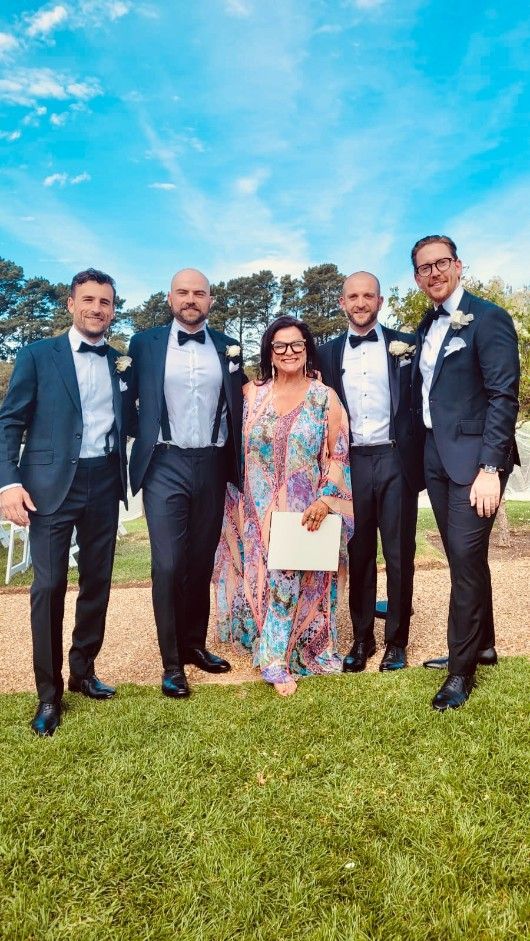 A Group of Men in Suits and Bow Ties Are Posing for A Picture