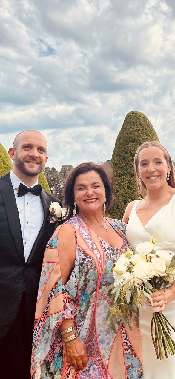 A Bride and Groom Are Posing for A Picture with Their Mother