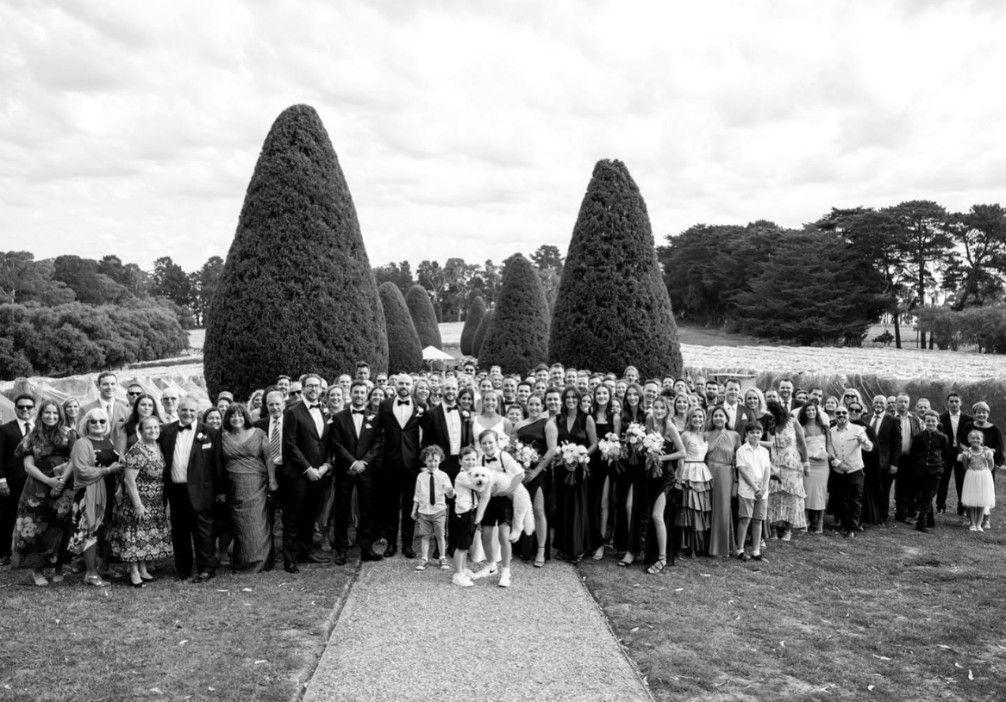 A Large Group of People Are Posing for A Picture in A Park