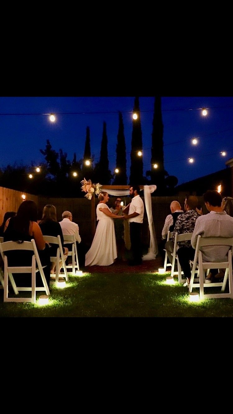 A Bride and Groom Are Getting Married in A Backyard at Night